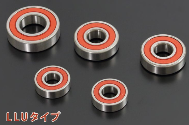 Five metal bearings with red inner races on a black background