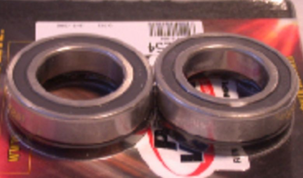 Two metal bearings on a red and black background with visible branding.