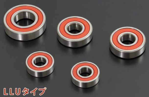 Five metal bearings with red inner races on a black background
