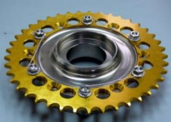 Gold sprocket with metal center on a gray background