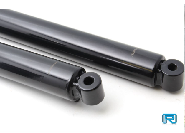 Two black metal shock absorbers on a white background