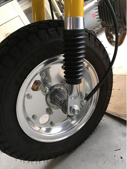Close-up of a bicycle wheel with a visible hub and tire on a concrete surface.