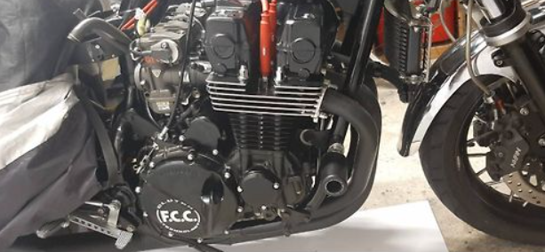 Close-up of a motorcycle engine with visible branding on a concrete floor.