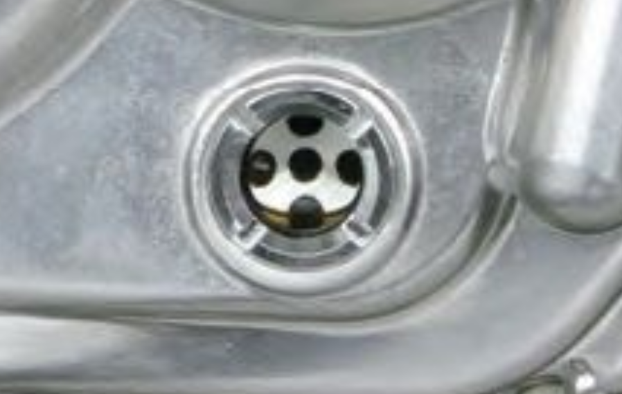 Close-up of a metallic sink drain with water flowing.