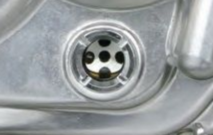 Close-up of a metallic sink drain with water flowing.