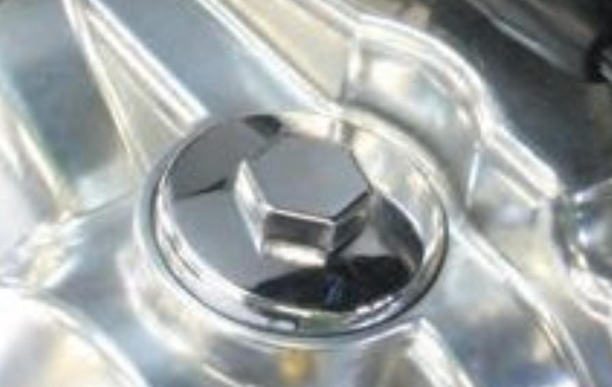 Close-up of a shiny metal cap on a reflective surface