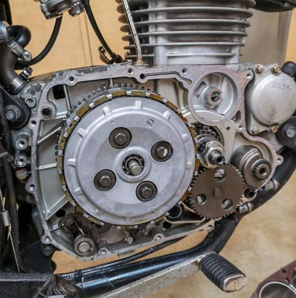 Close-up of a motorcycle engine with gears and mechanical components.