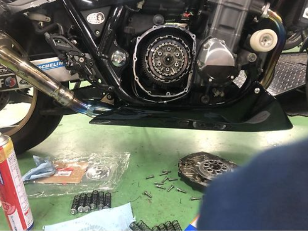 Close-up of a motorcycle engine with tools and parts on a workbench