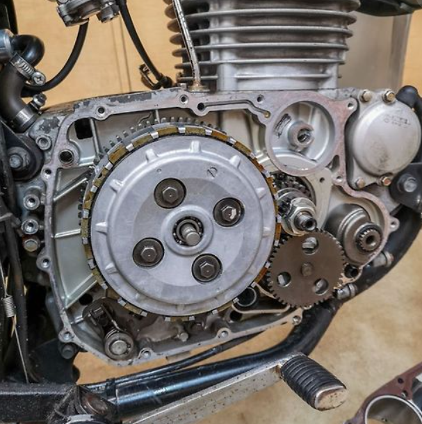 Close-up of a motorcycle engine with gears and mechanical components.