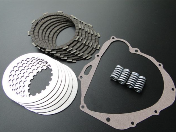 Mechanical components including a clutch plate, gasket, and springs on a dark background