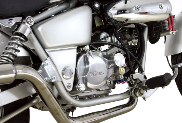 Close-up of a motorcycle engine and exhaust system on a white background