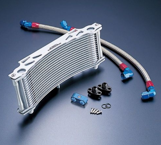 Metallic oil cooler with hoses and connectors on a dark background