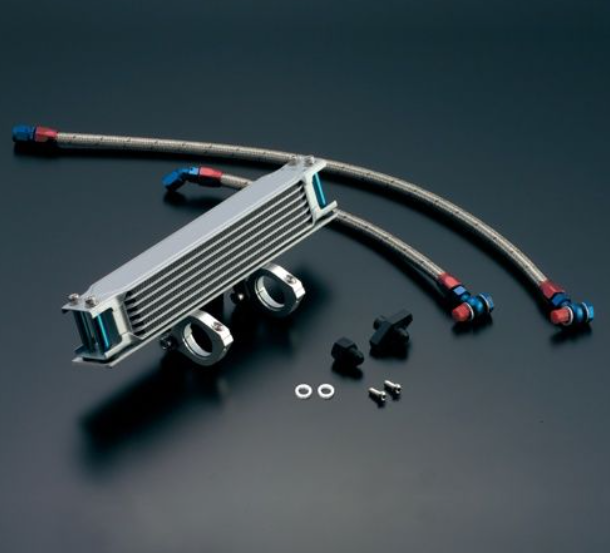 Metallic oil cooler with hoses and connectors on a dark background