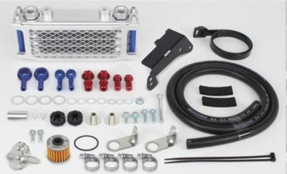 Collection of automotive parts including a metal grille, hoses, and connectors on a white background