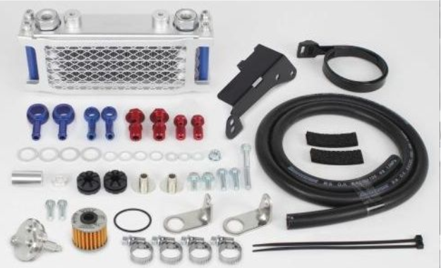 Collection of automotive parts including a metal grille, hoses, and connectors on a white background