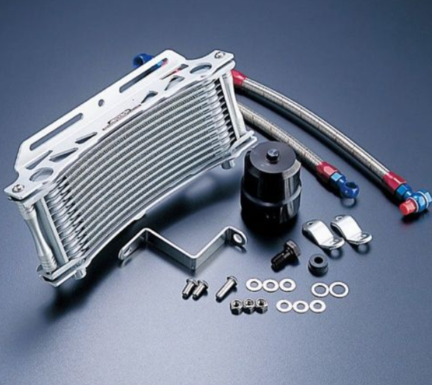 Metallic oil cooler kit with hoses and accessories on a dark background