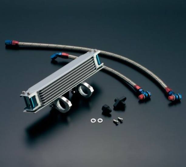Metallic oil cooler with hoses and connectors on a dark background