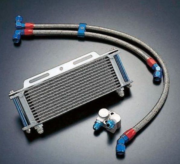 Oil cooler with hoses and connectors on a dark background