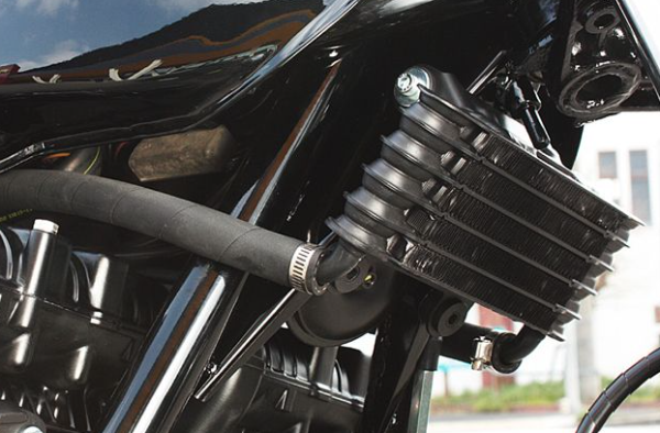 Close-up of a motorcycle engine and exhaust system with a blurred background.