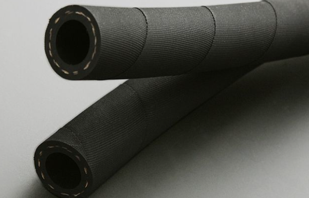 Two rolls of black textured material on a gray background