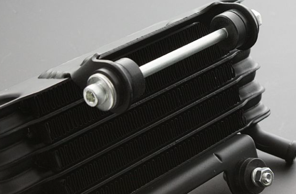 Close-up of a black radiator with metallic components on a gray background
