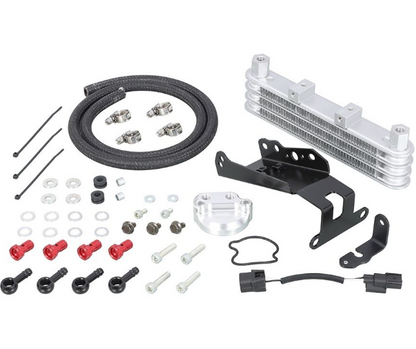 Collection of automotive parts including a metal oil cooler, hoses, and connectors on a white background.