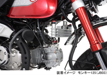 Close-up of a motorcycle engine and red suspension fork on a white background