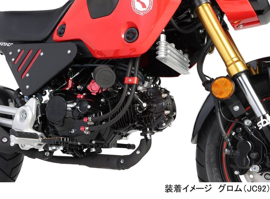 Close-up of a red motorcycle with visible engine and suspension components.