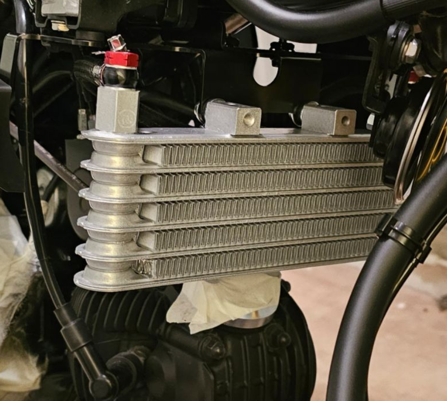 Close-up of a motorcycle radiator with visible pipes and components.
