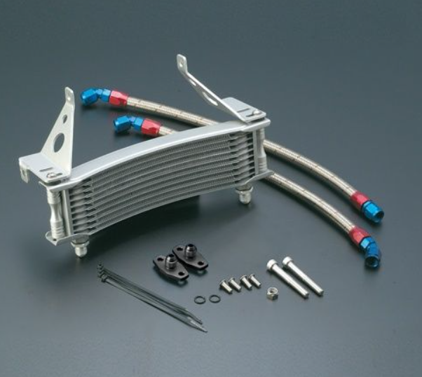 Metallic oil cooler with hoses and accessories on a gray background