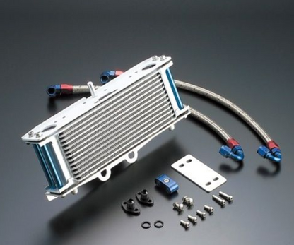Oil cooler with hoses and mounting hardware on a gray background