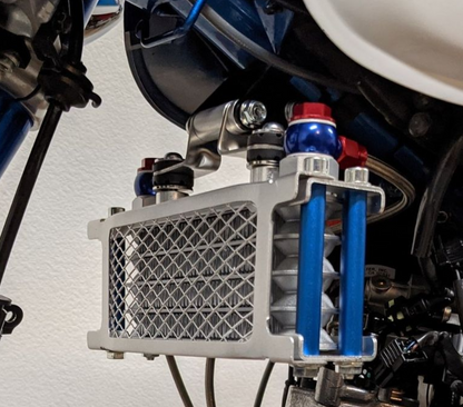 Close-up of a motorcycle's engine and cooling system with a white background