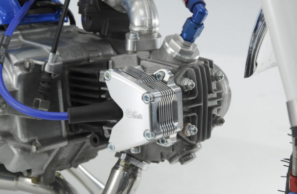 Close-up of a motorcycle engine with visible branding on a white background
