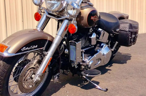 Harley-Davidson motorcycle parked on a paved surface with a beige wall in the background.
