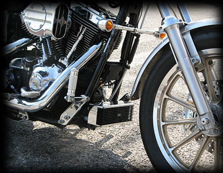 Close-up of a motorcycle's engine and wheel on a textured surface