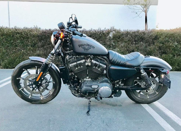 Harley Davidson motorcycle parked on a paved surface with a blurred background