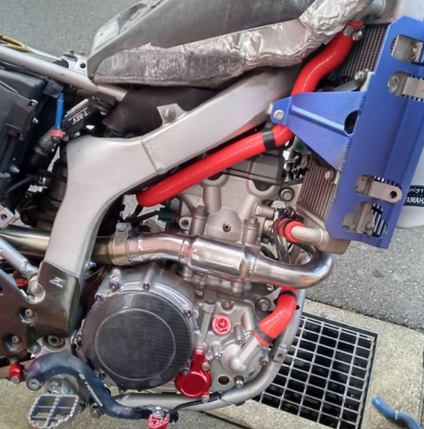 Close-up of a motorcycle engine with visible branding on a street.