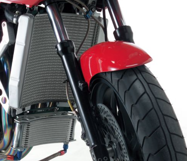 Close-up of a motorcycle's radiator and front wheel on a white background