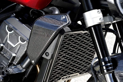 Close-up of a motorcycle's radiator and carbon fiber cover