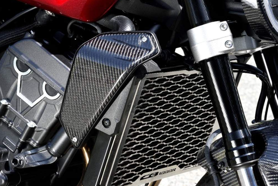 Close-up of a motorcycle's radiator and carbon fiber cover