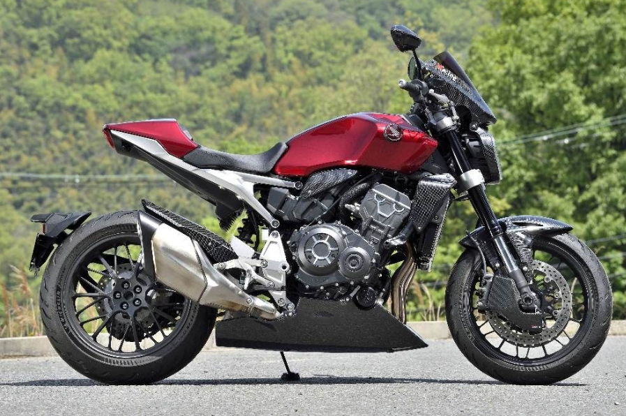 Red motorcycle on a road with greenery in the background