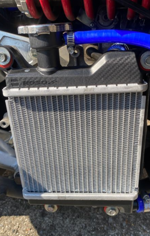 Motorcycle radiator with visible branding on a blurred background