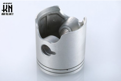 Metal piston on a light gray background with 'Kobe' branding.