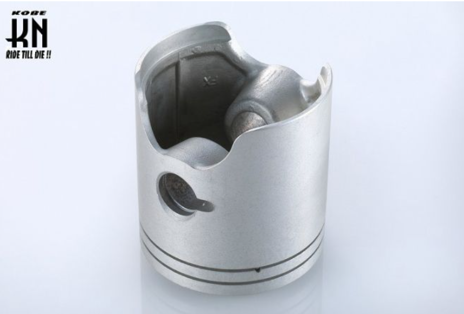 Metal piston on a light gray background with 'Kobe' branding.