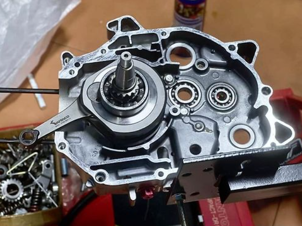 Mechanical engine component on a workbench with tools and parts in the background