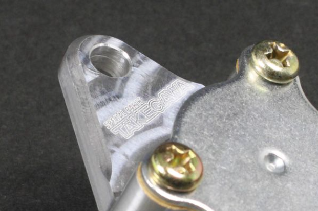 Metal component with screws on a dark background