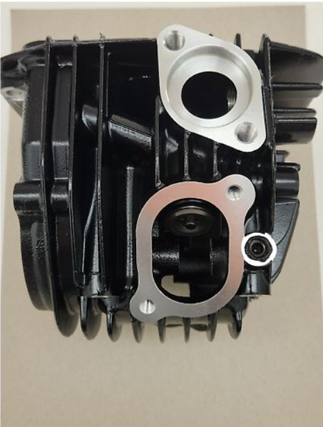 Black mechanical component with metallic parts on a beige background