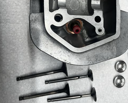 Car engine parts including a head gasket and valves on a metallic surface