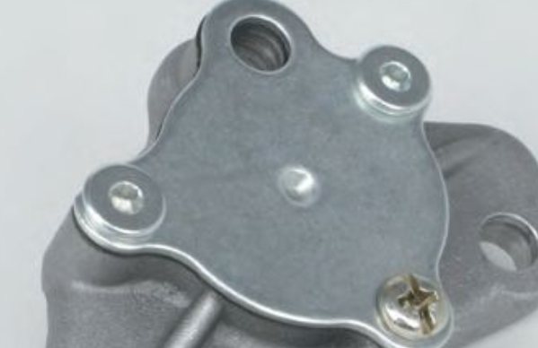 Metal mechanical component with screws on a light gray background
