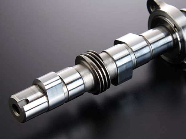 Close-up of a metallic camshaft on a dark background